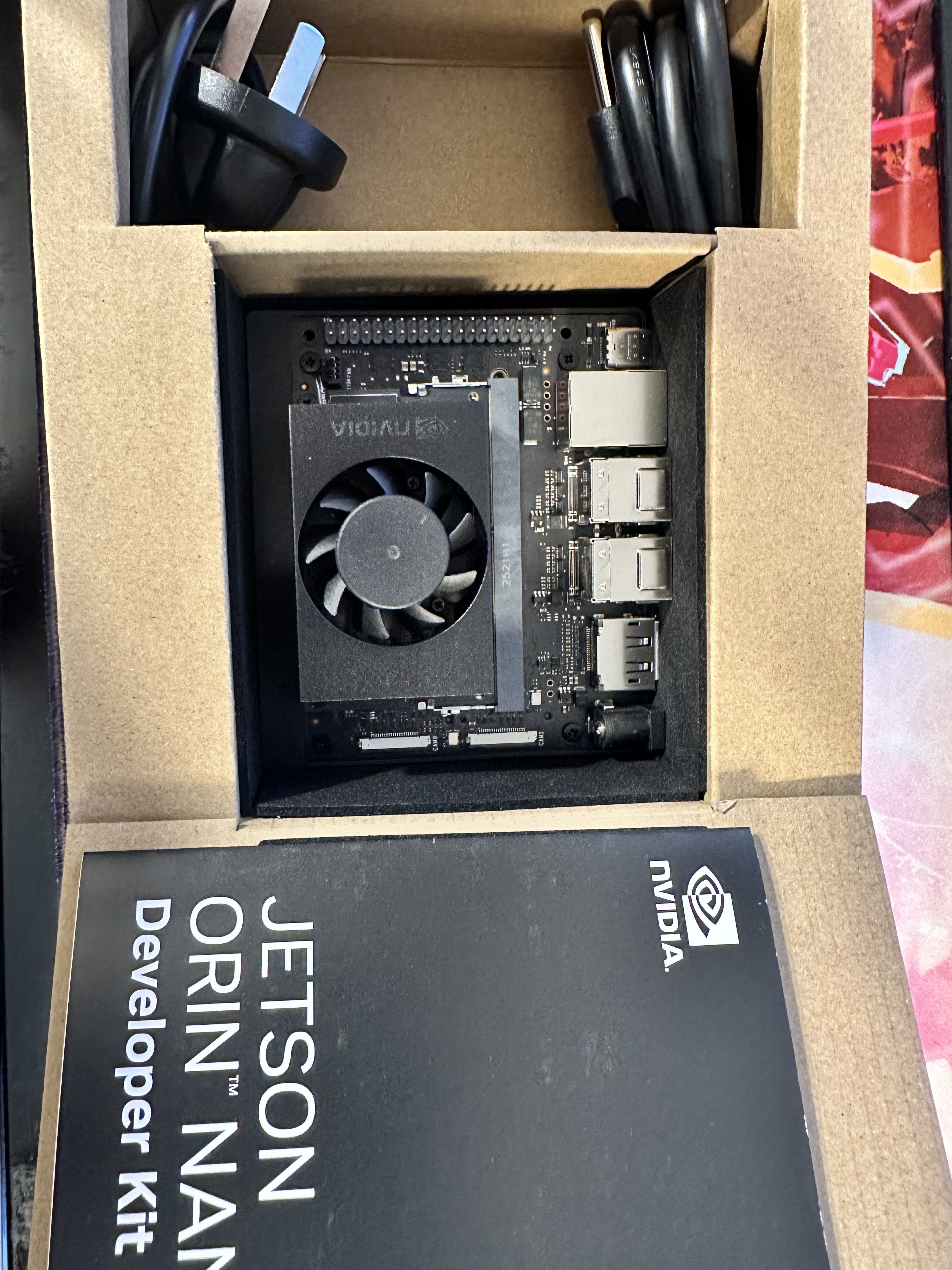 Jetson Orin Nano developer kit in its box with the board, fan, and documentation visible